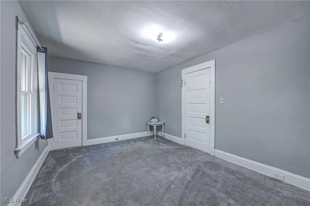 Carpeted empty room featuring baseboards