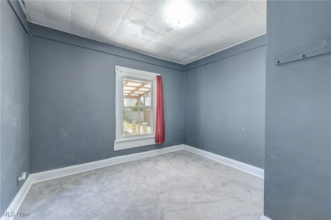 Carpeted empty room featuring baseboards