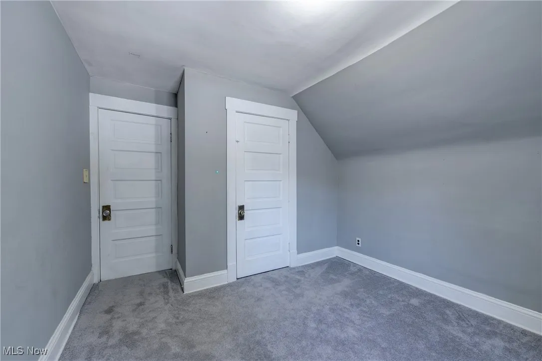 Additional living space with carpet floors and lofted ceiling