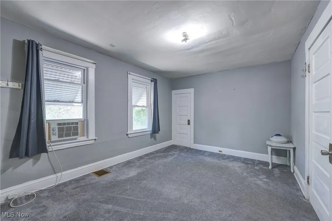 Spare room featuring carpet and cooling unit