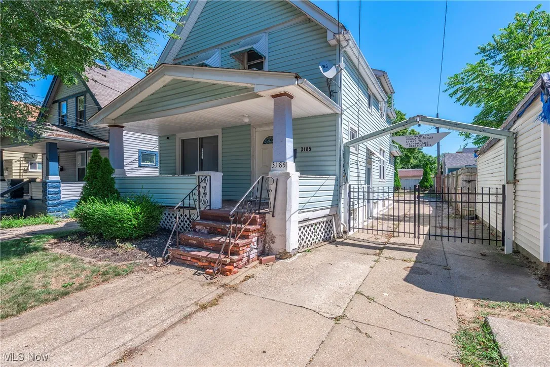 View of front facade with a porch, driveway, and a carport