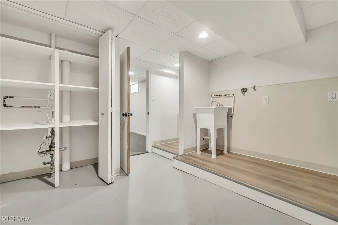 Finished basement featuring a paneled ceiling and baseboards