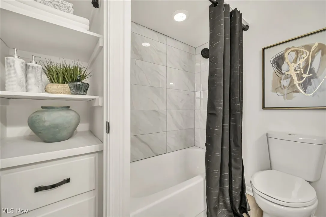 Bathroom featuring shower / tub combo with curtain and vanity
