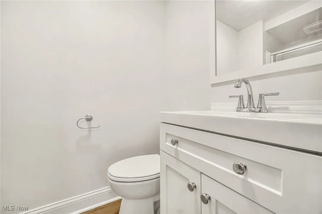 Half bath featuring vanity and wood finished floors