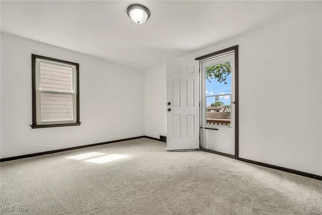 Empty room with baseboards and carpet