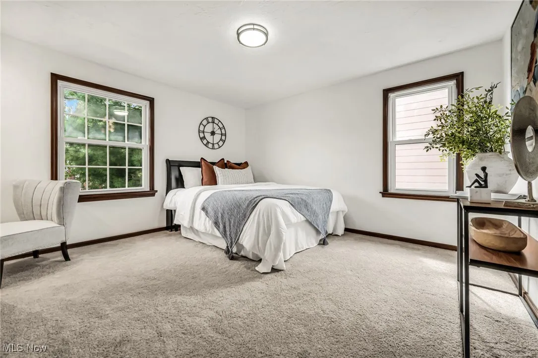 Bedroom featuring carpet and baseboards