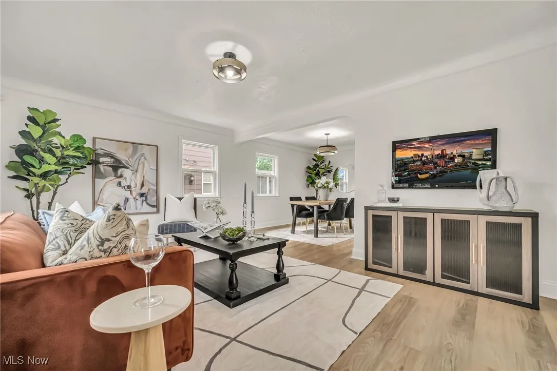 Living room with light wood-type flooring and beamed ceiling