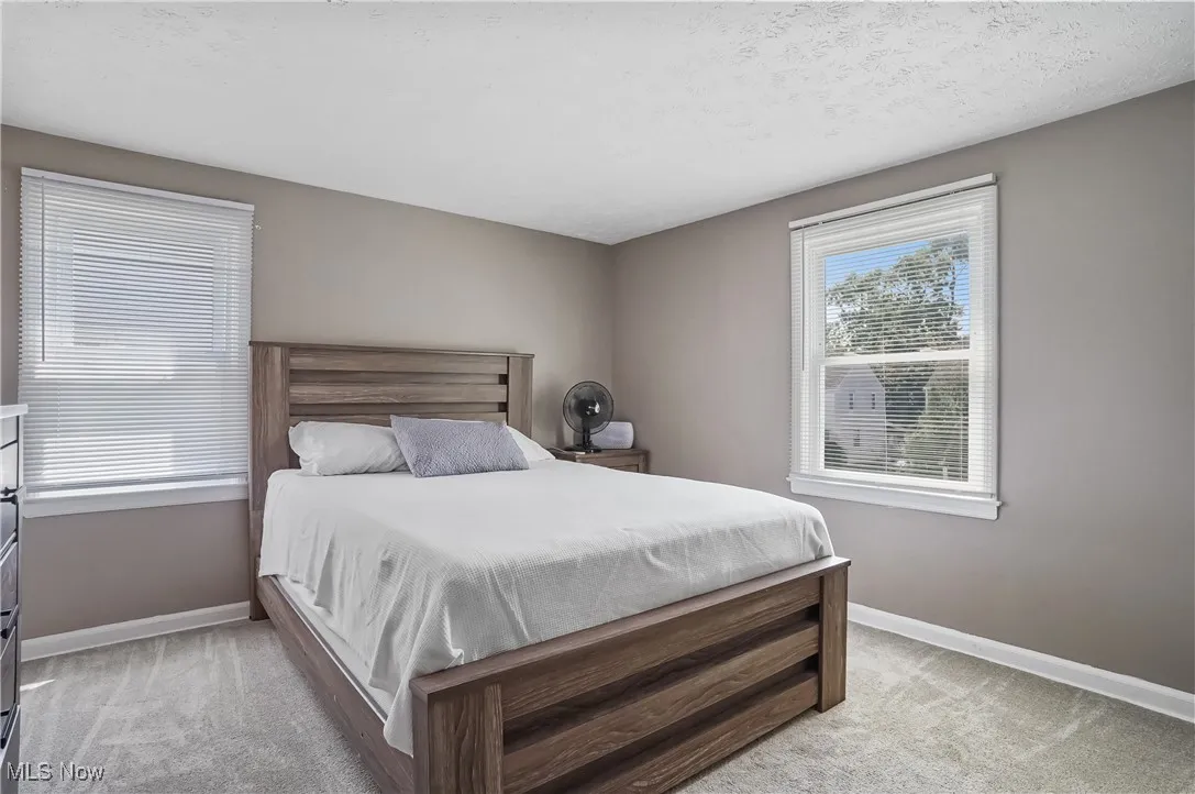 Bedroom featuring a textured ceiling and light colored carpet