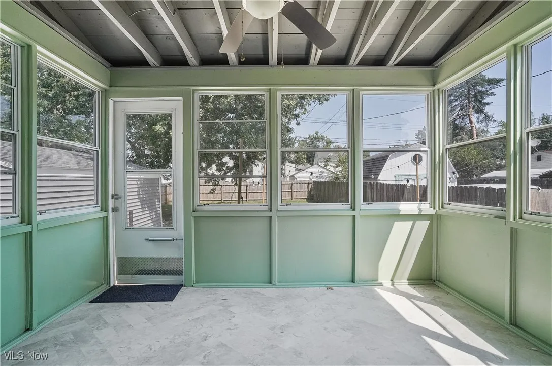 Unfurnished sunroom featuring ceiling fan and plenty of natural light