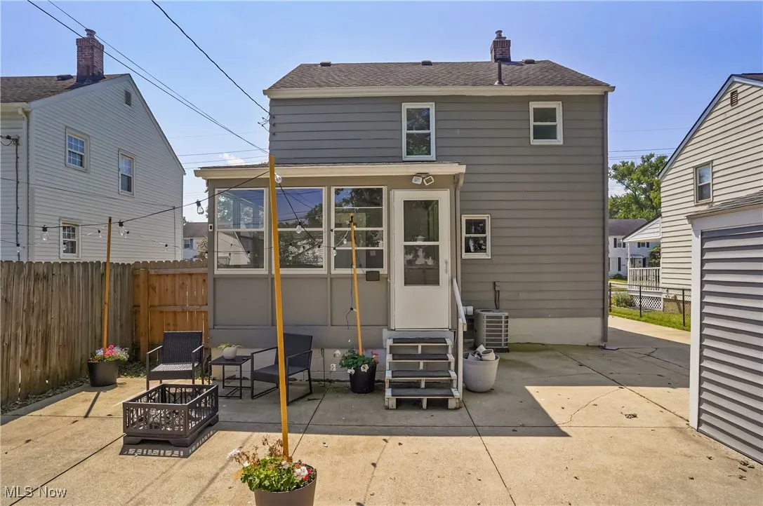 Back of house with a patio area, an outdoor fire pit, a chimney, a shingled roof, and entry steps