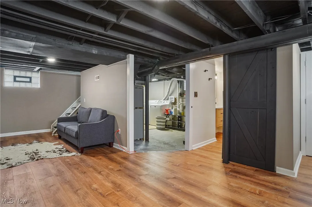 Below grade area featuring light wood-style flooring and a barn door