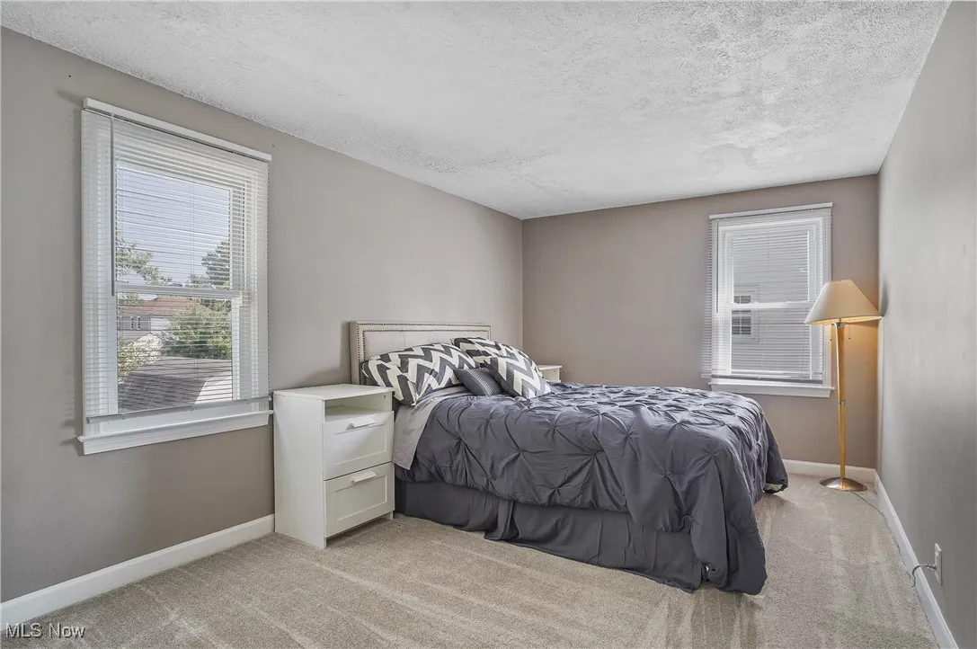 Bedroom featuring light carpet and a textured ceiling