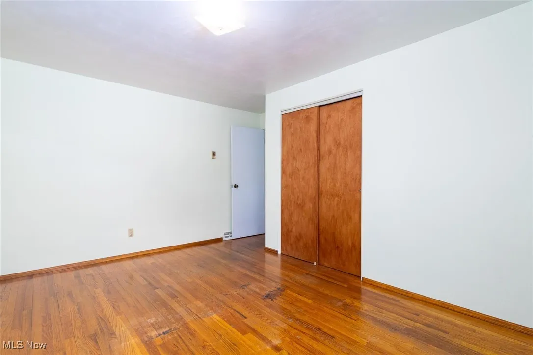 Unfurnished bedroom featuring hardwood / wood-style flooring and a closet