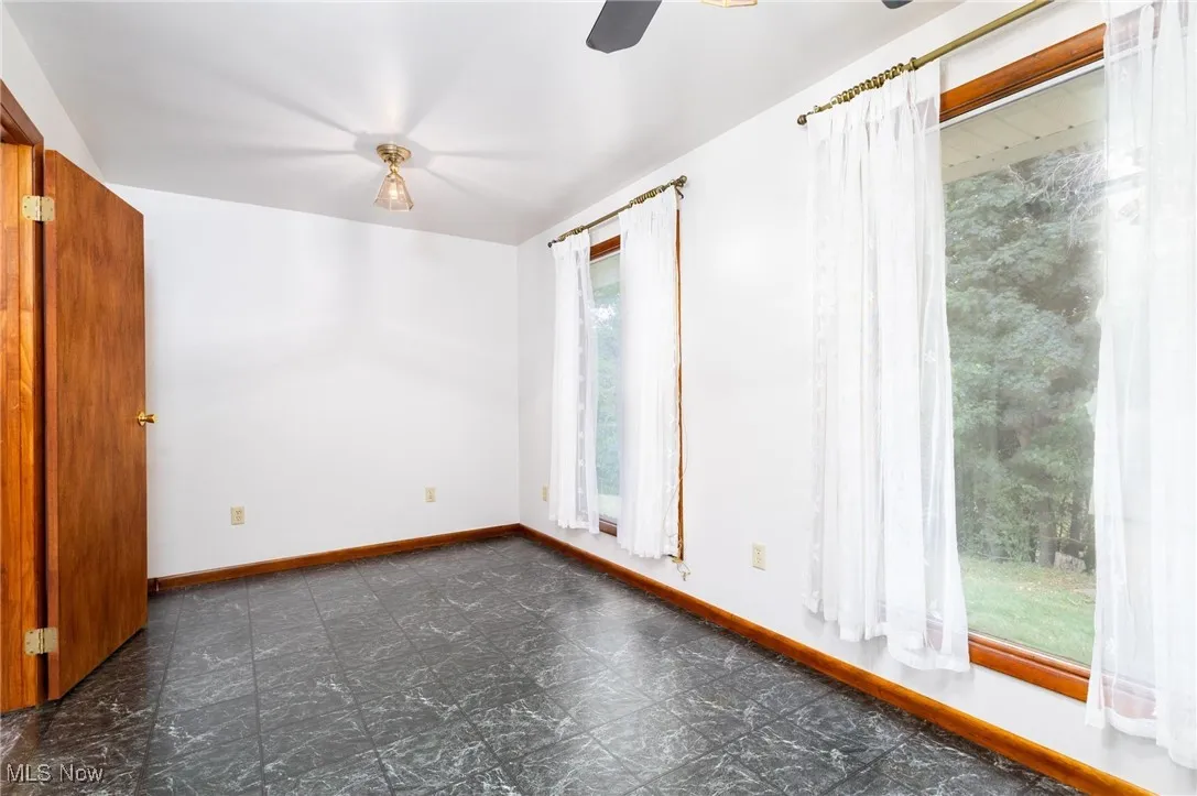 Spare room featuring baseboards and ceiling fan