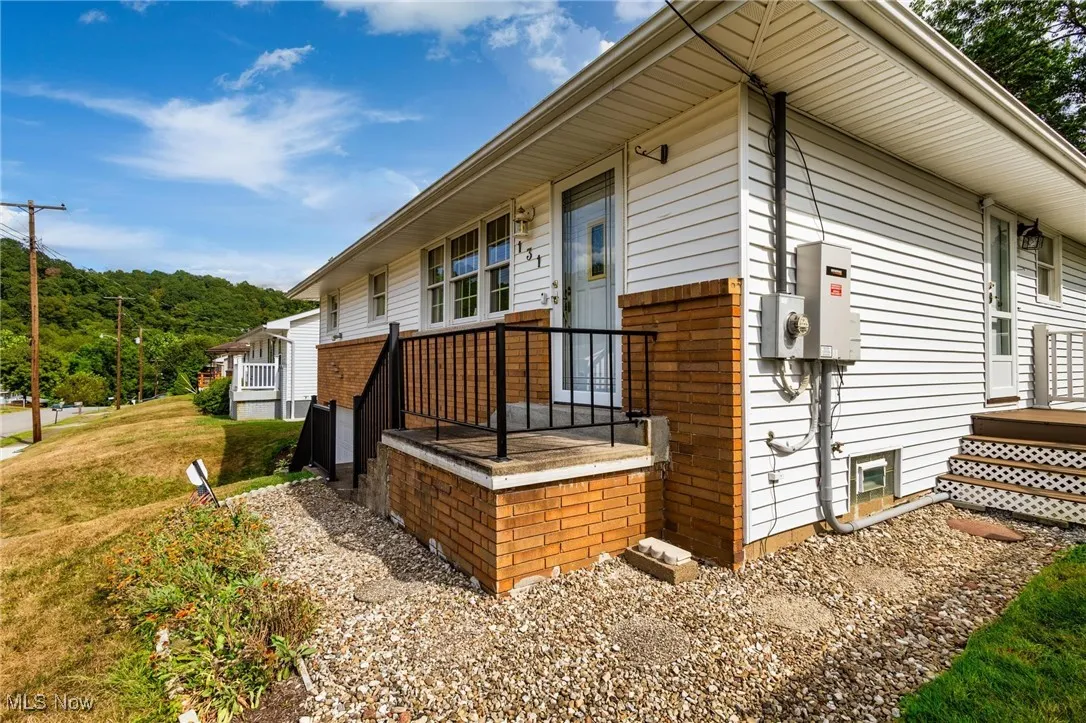 View of property exterior with brick siding and a deck