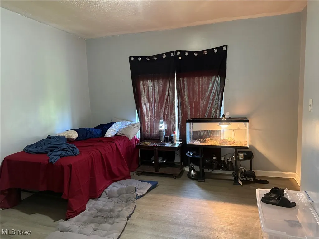 Bedroom with wood finished floors and a textured ceiling
