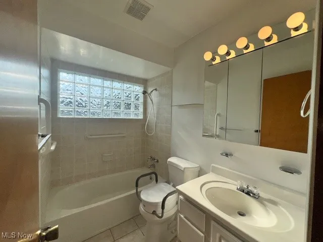 Bathroom with bathtub / shower combination, vanity, and light tile patterned floors