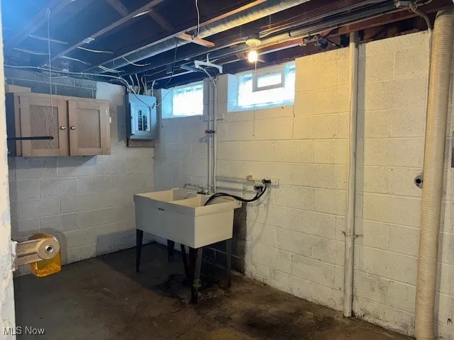 Basement featuring a sink and electric panel