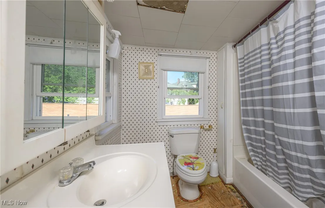 Bathroom with shower / bathtub combination with curtain and vanity