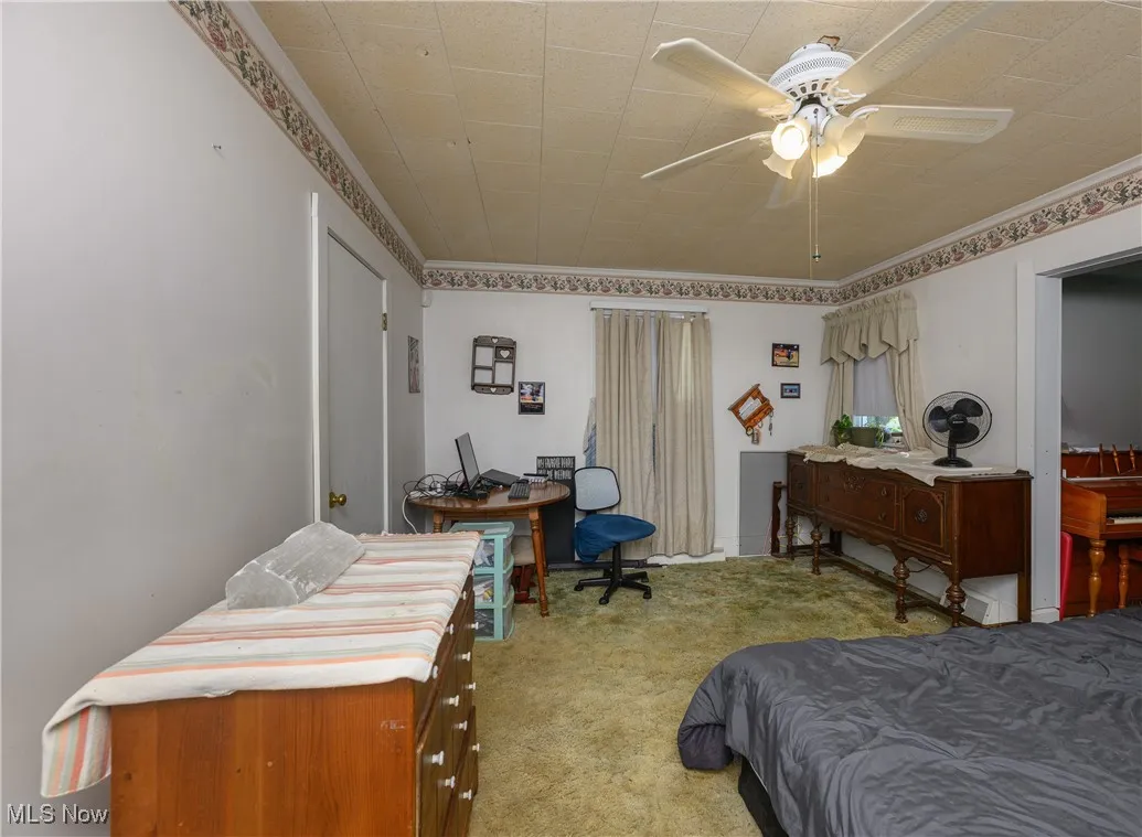 Bedroom with carpet, ceiling fan, and ornamental molding
