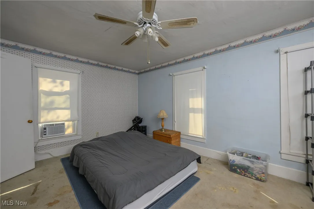 Bedroom featuring ceiling fan and concrete floors