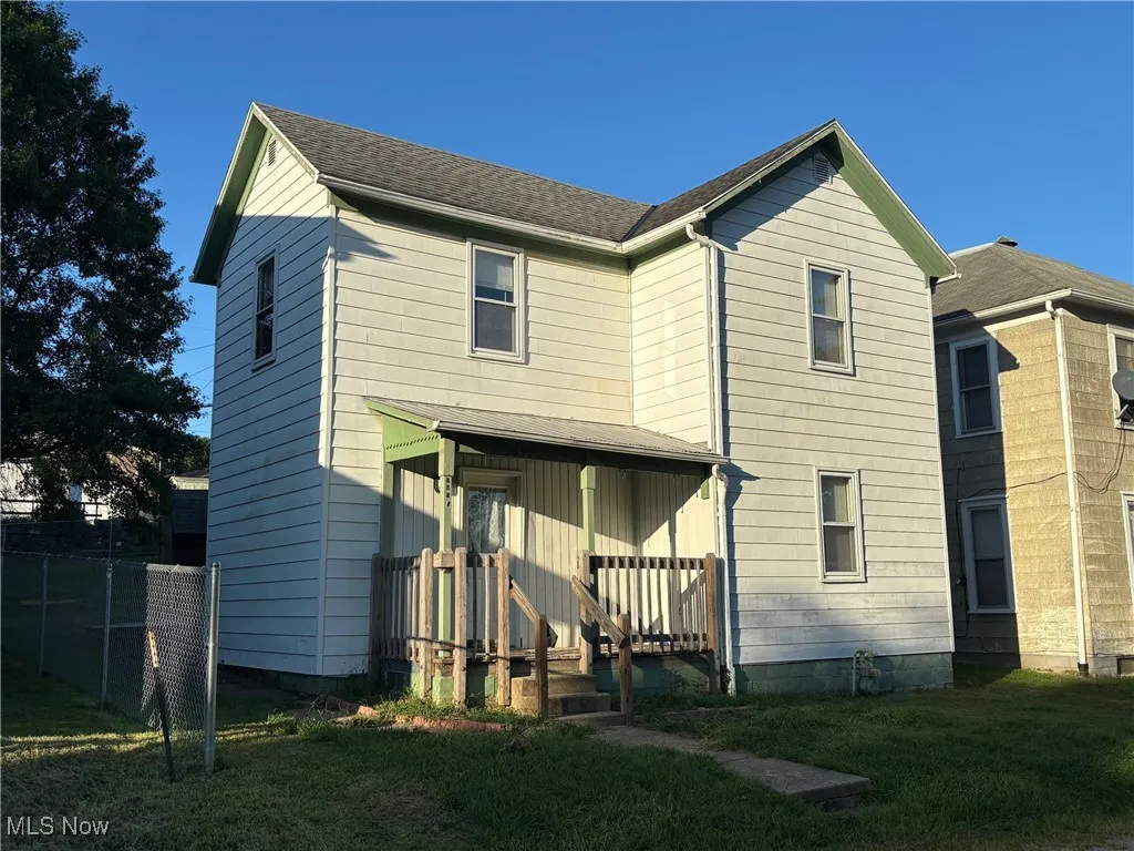 Rear view of house featuring roof with shingles