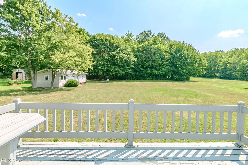 View of green lawn featuring an outbuilding