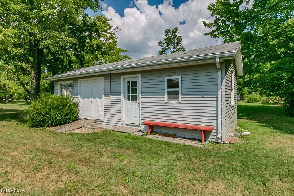 Rear view of house with a yard and an outbuilding