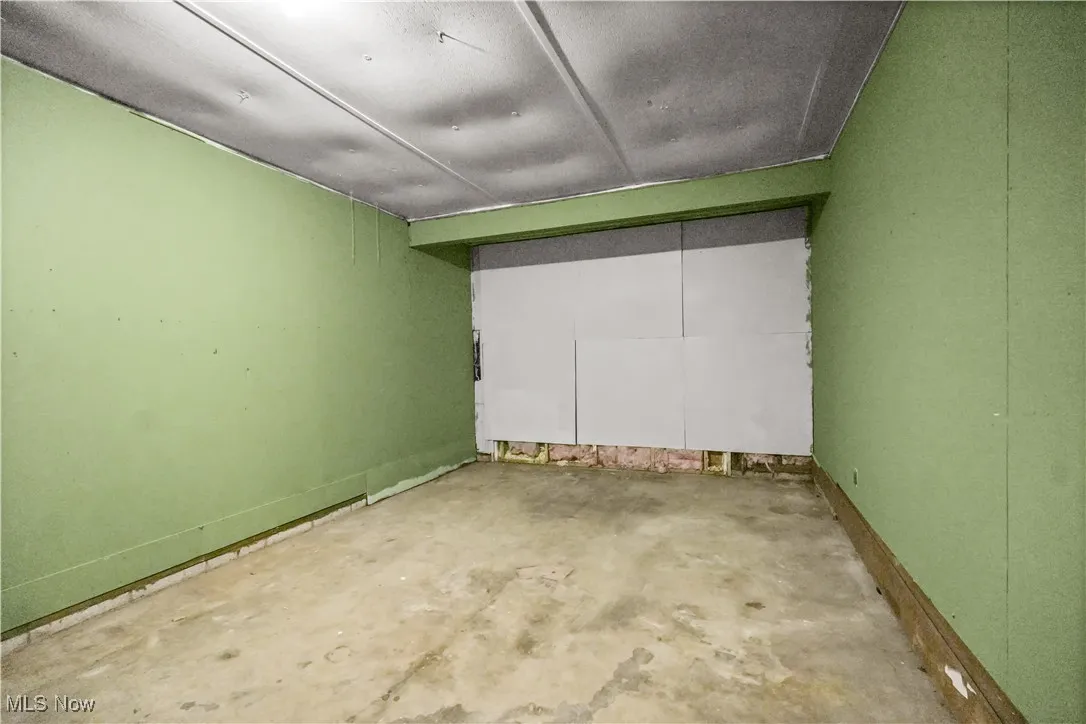 Empty room featuring unfinished concrete flooring
