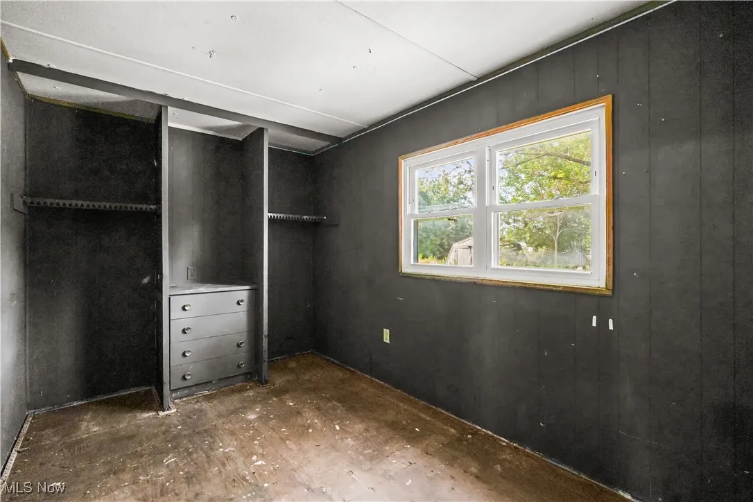 Unfurnished bedroom with wood walls