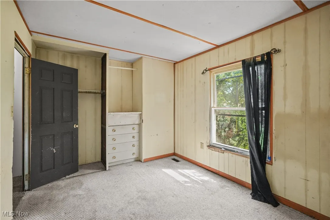 Unfurnished bedroom with carpet flooring and a closet