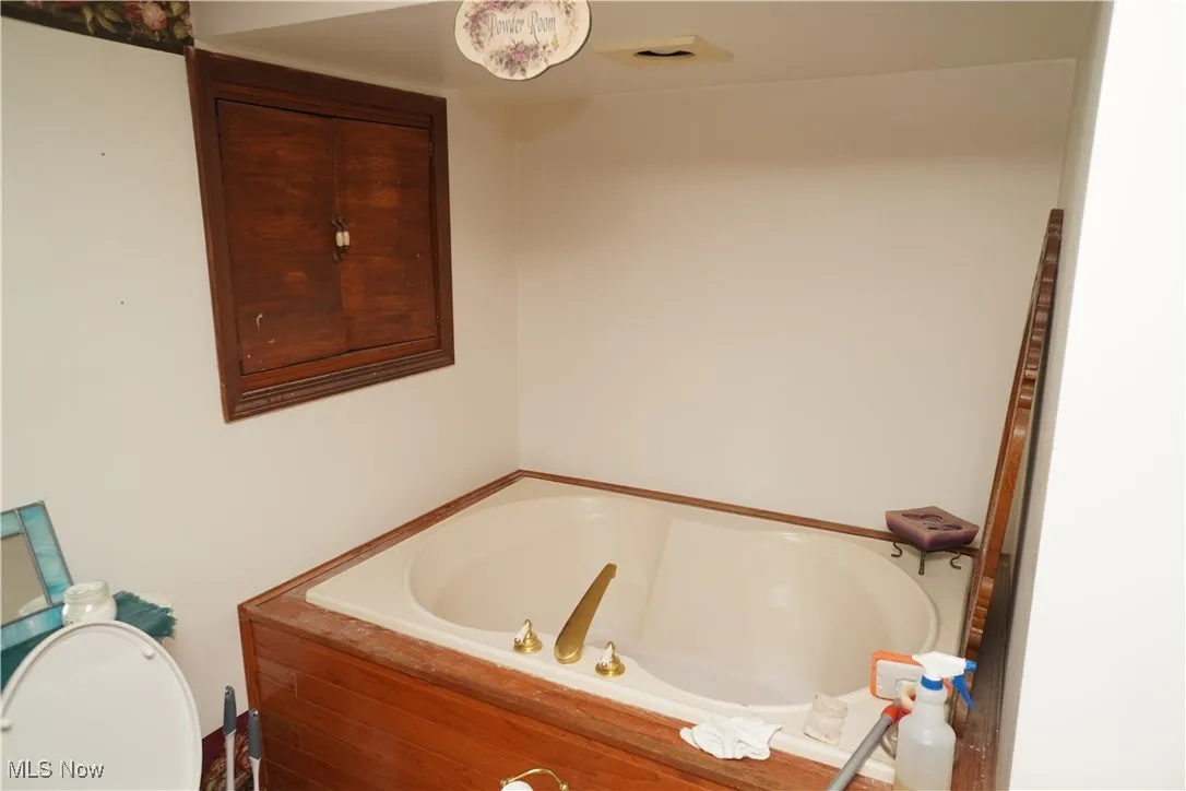 Full bathroom with a garden tub and toilet