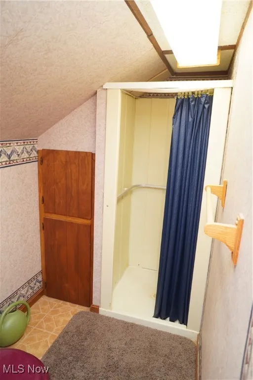 Bathroom with lofted ceiling and a textured ceiling