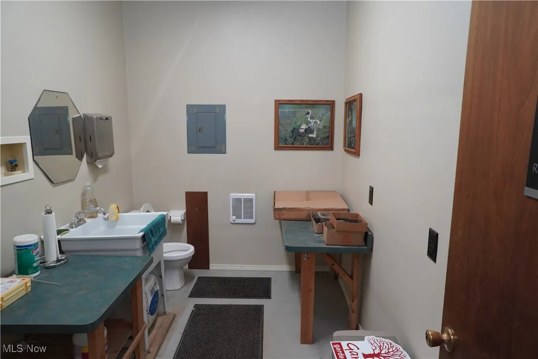 Half bath featuring electric panel, heating unit, and vanity