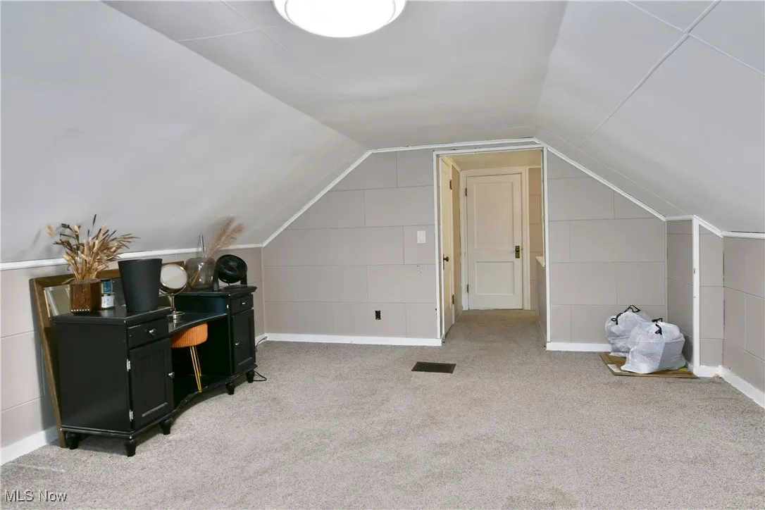 Bonus room featuring lofted ceiling and carpet floors