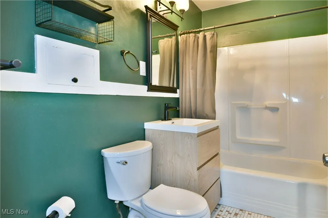 Bathroom featuring shower / tub combo with curtain and vanity