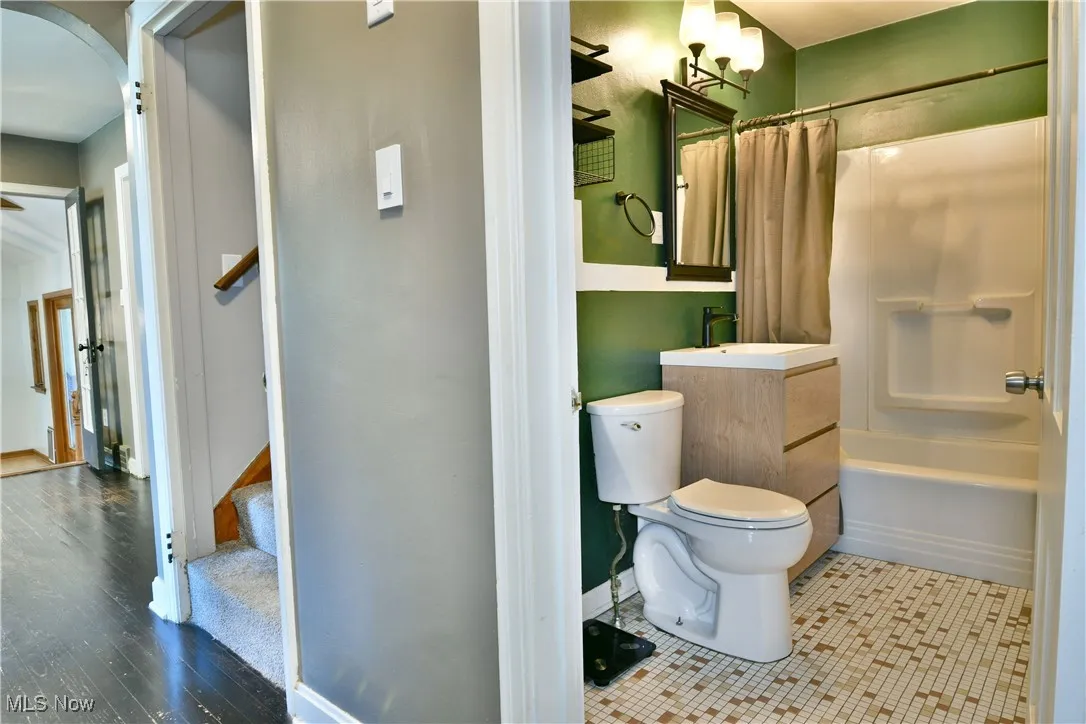 Bathroom with shower / bath combo with shower curtain and vanity