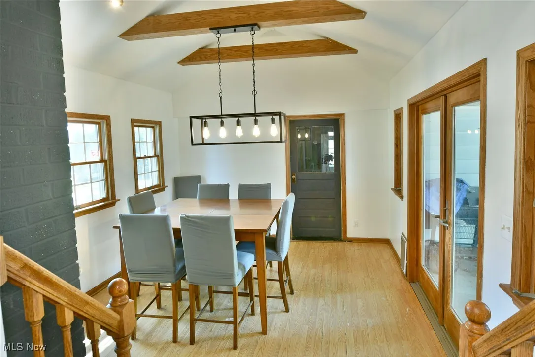 Dining room featuring light wood-type flooring, stairway, and french doors
