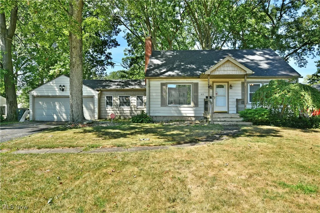 View of front of home featuring a chimney, a front yard, and an attached garage