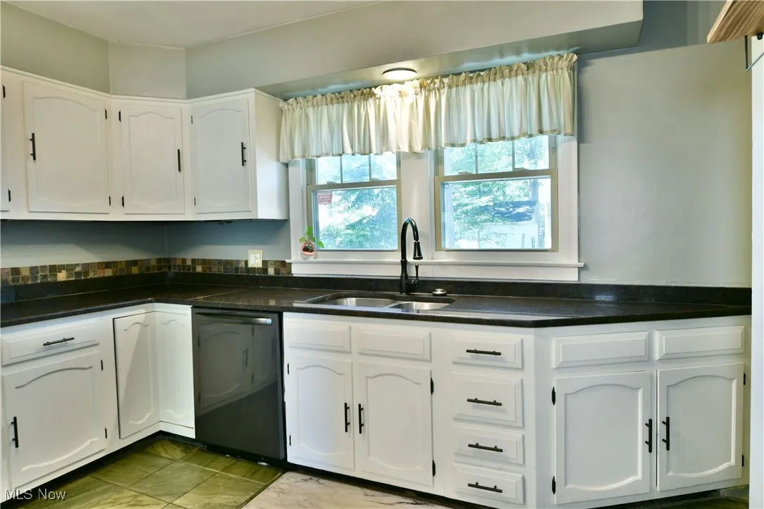 Kitchen featuring white cabinets and dishwasher