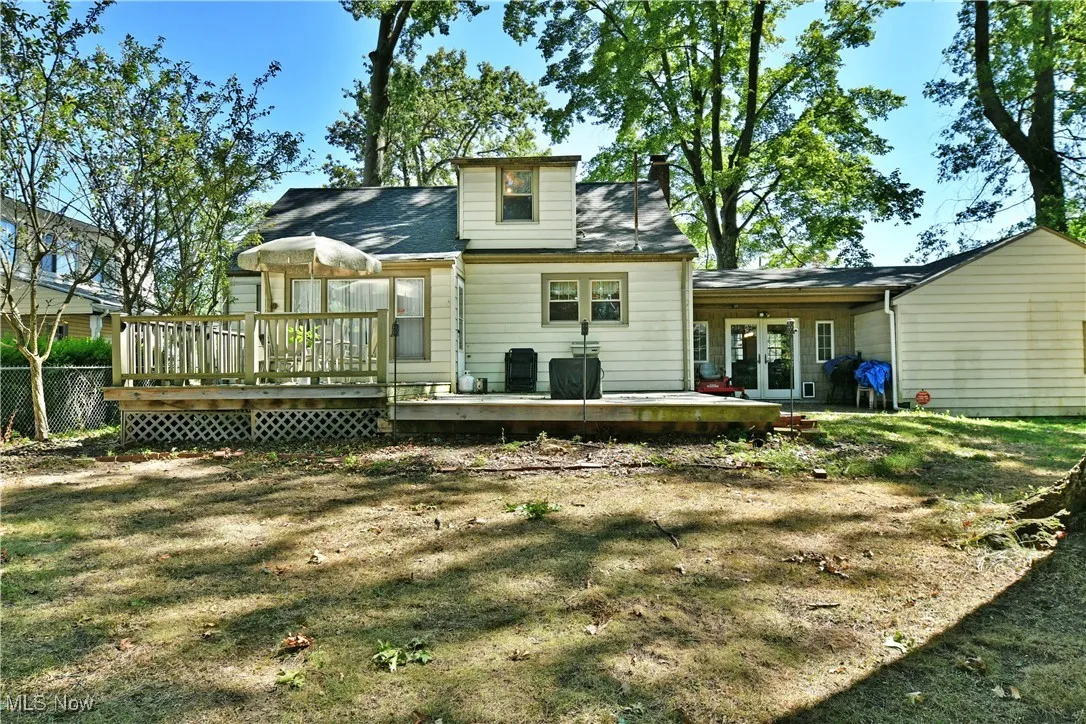 Back of house with a wooden deck, french doors, and a patio