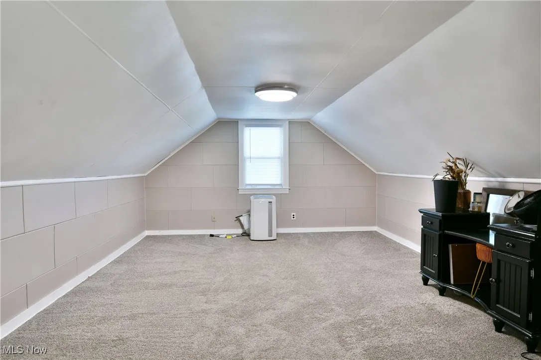Bonus room with light carpet and lofted ceiling
