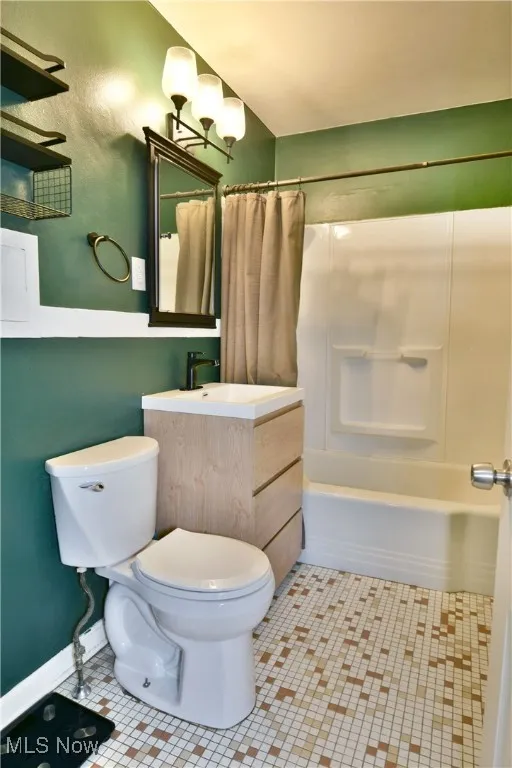 Full bath with vanity, shower / tub combo, and tile patterned floors