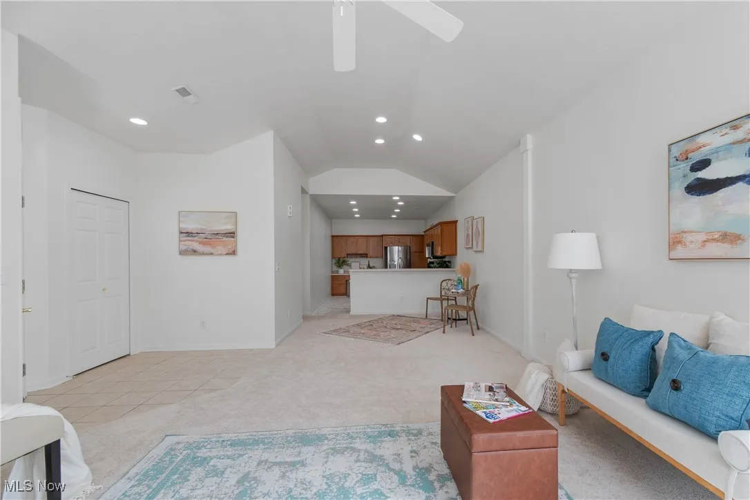 Living room featuring vaulted ceiling, light carpet, and recessed lighting