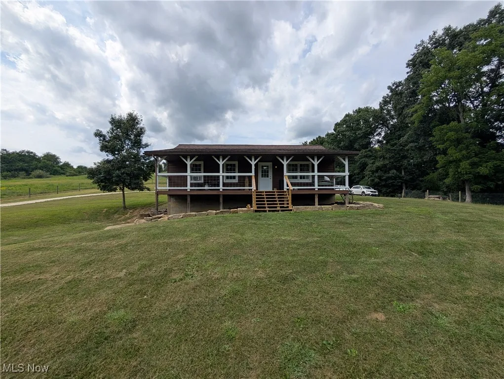 View of front of house with a front yard and a porch
