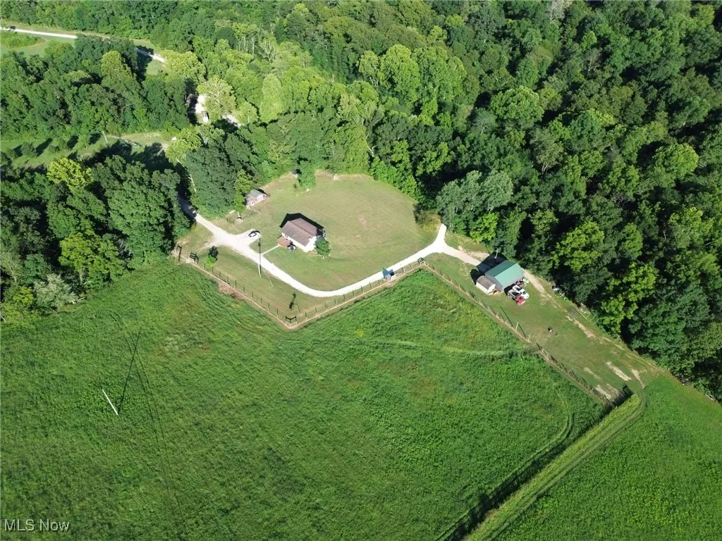 Aerial view of property's location with a heavily wooded area