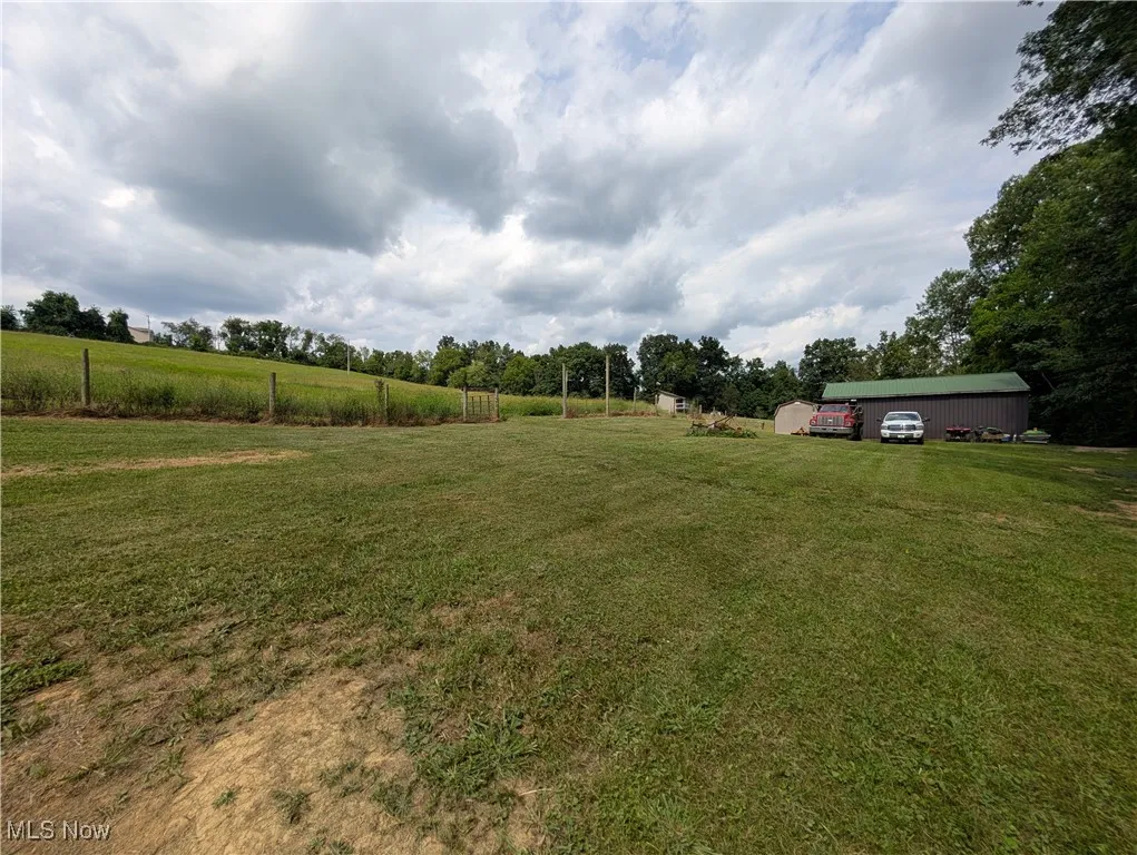 View of green lawn featuring an outbuilding and a view of countryside