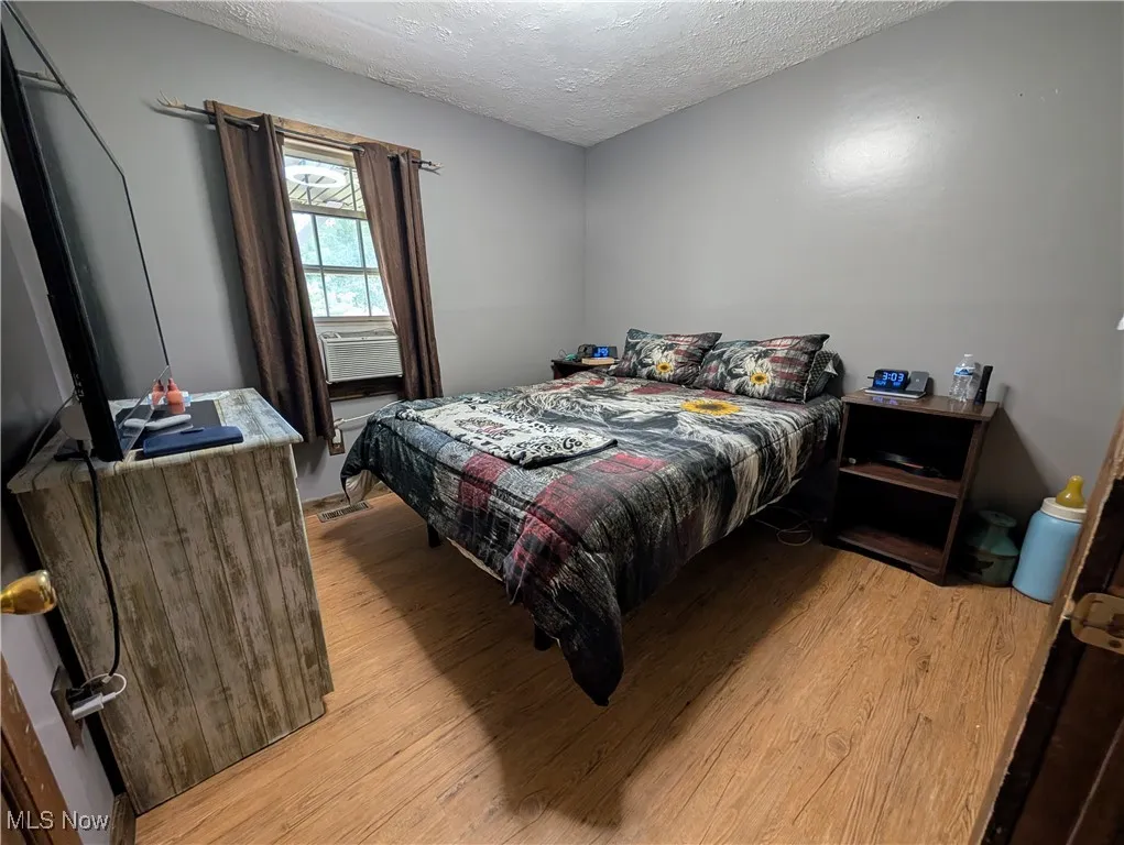 Bedroom featuring light wood-style flooring and a textured ceiling