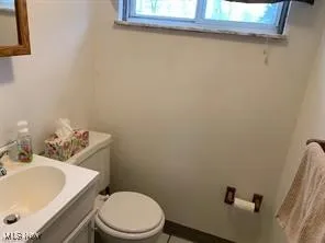 Half bath with vanity and tile patterned floors