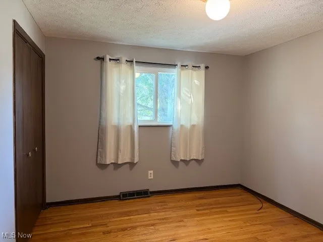 Bedroom with ceiling light and wood-flooring and a ceiling light.